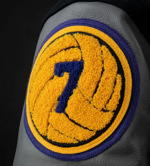 Detailed close-up of a custom yellow and blue chenille volleyball patch