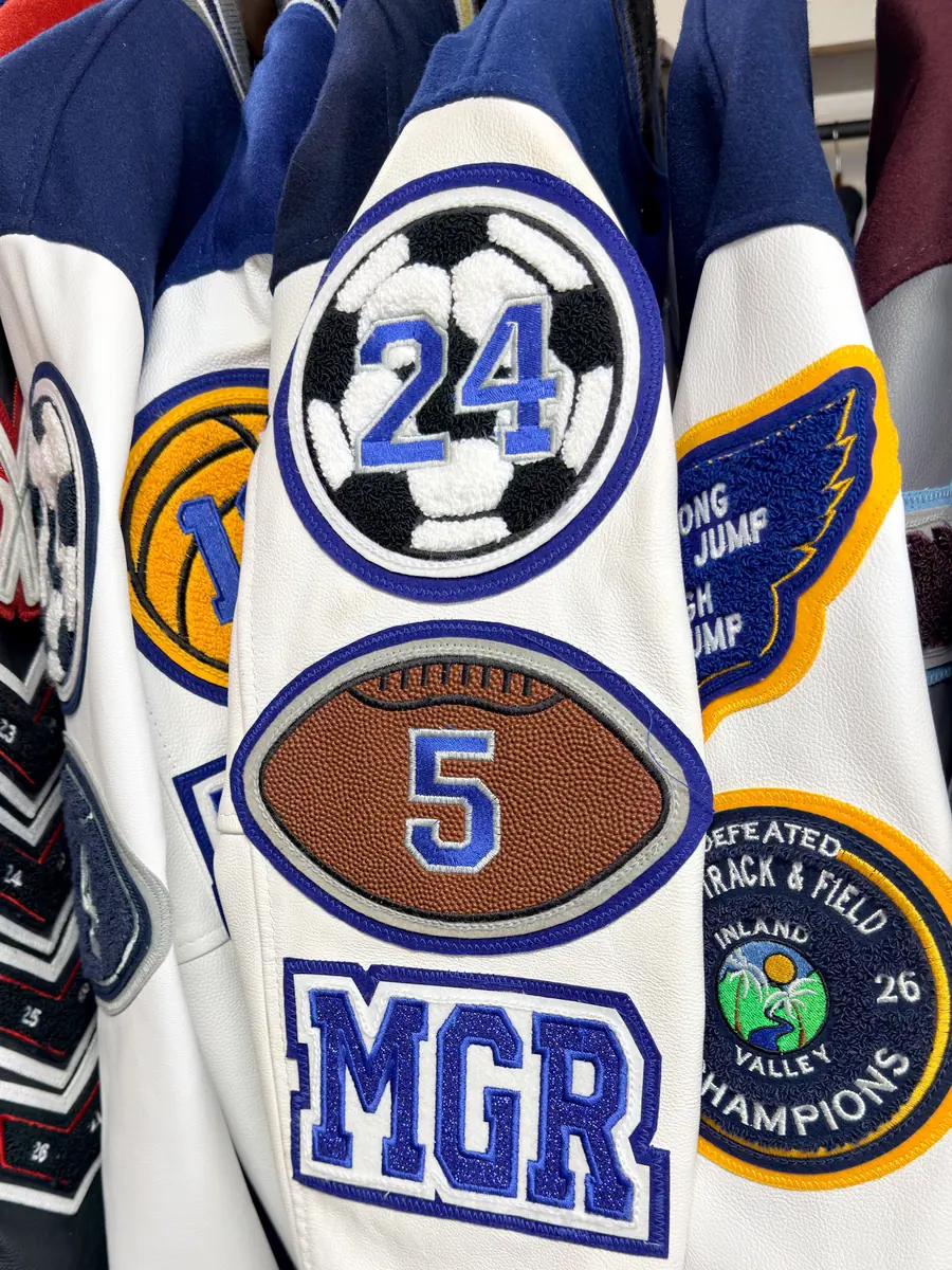 Custom letterman jacket sleeve with soccer, football, track and field, and manager patches